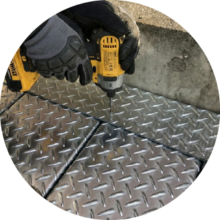 鋼製平面の塞ぎ板を止めている様子