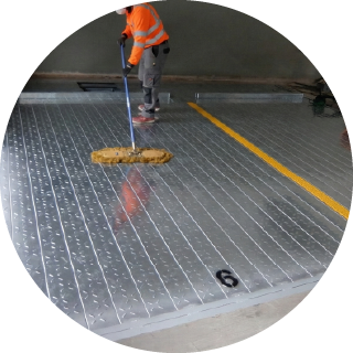 鋼製平面の上をモップで掃除している